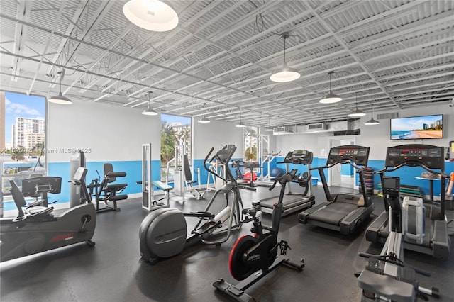 workout area with a wealth of natural light and a water view