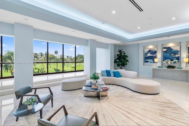 tiled living room with a tray ceiling and a healthy amount of sunlight