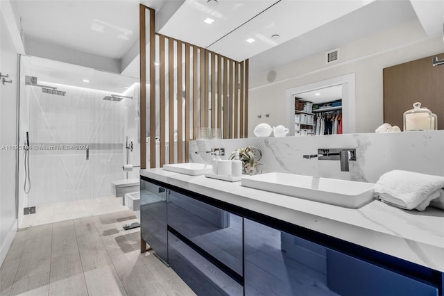 bathroom featuring a shower with door, vanity, hardwood / wood-style floors, and toilet