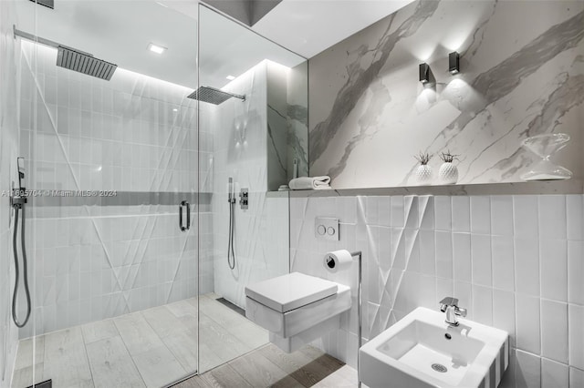 bathroom with sink, a shower with door, tile walls, and a bidet