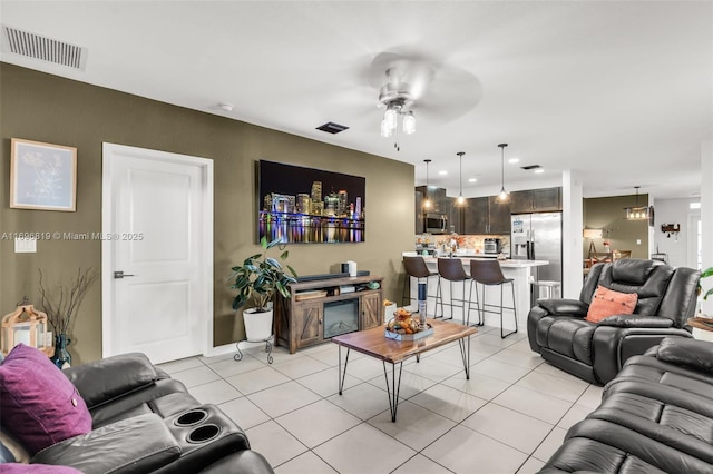 living room featuring light tile patterned floors and ceiling fan