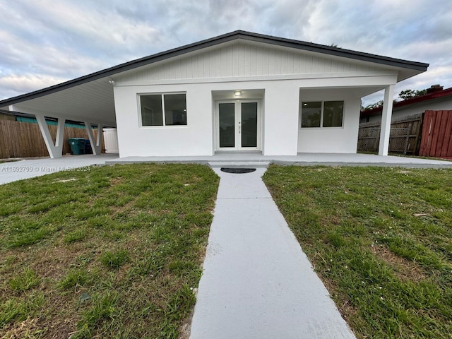 view of front facade featuring a patio area, french doors, and a front lawn