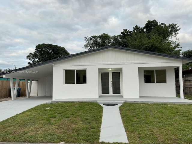 view of front of house featuring french doors, a front lawn, and a carport