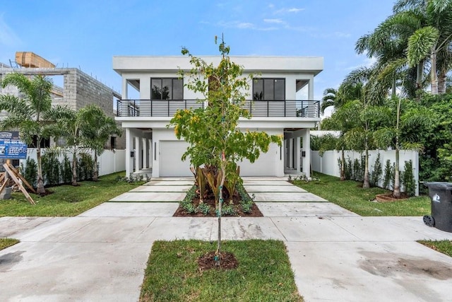 view of front facade with a front yard, a balcony, and a garage