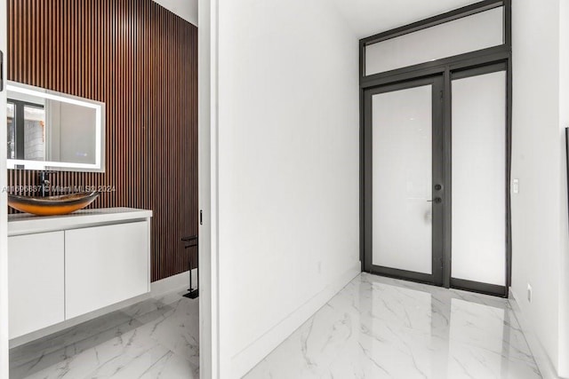 bathroom with vanity and wood walls