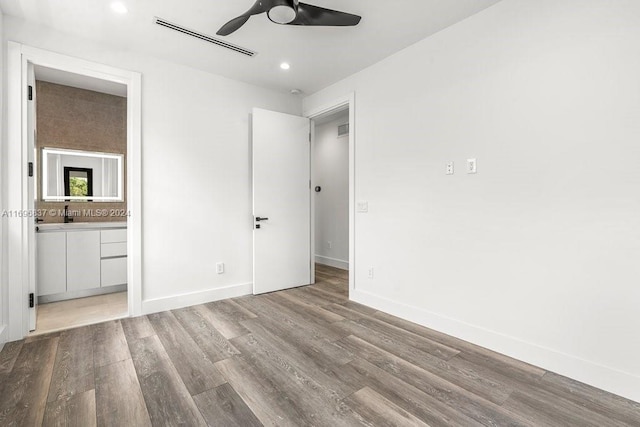 unfurnished bedroom featuring ensuite bath, ceiling fan, and light hardwood / wood-style flooring