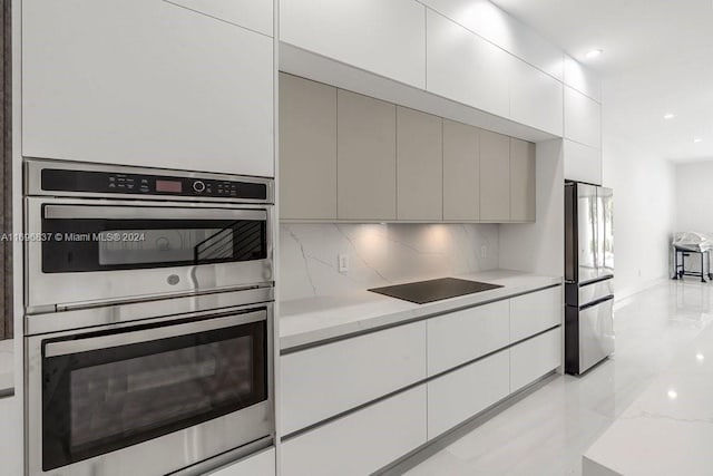 kitchen with decorative backsplash, light stone countertops, and appliances with stainless steel finishes