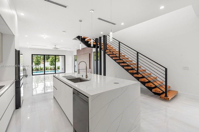 kitchen with dishwasher, white cabinetry, sink, and a large island with sink