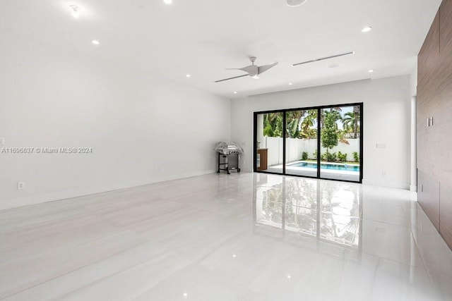 empty room with light tile patterned floors and ceiling fan