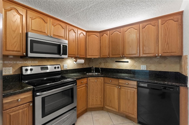7100 NW 17th St Unit 219, Plantation, FL 33313 - kitchen with stainless steel appliances, a sink, dark stone countertops, tasteful backsplash, and a textured ceiling