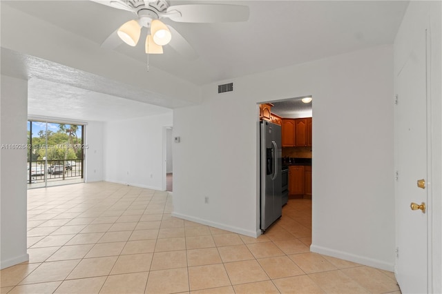 7100 NW 17th St Unit 219, Plantation, FL 33313 - spare room featuring light tile patterned floors, a ceiling fan, and baseboards