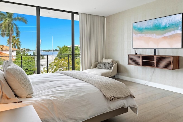 bedroom with multiple windows and hardwood / wood-style flooring