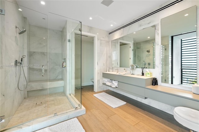 bathroom with hardwood / wood-style floors, vanity, toilet, and walk in shower