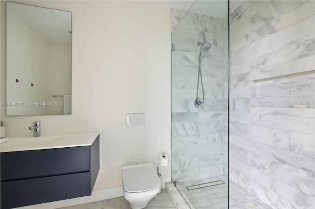 bathroom with a tile shower, vanity, and toilet