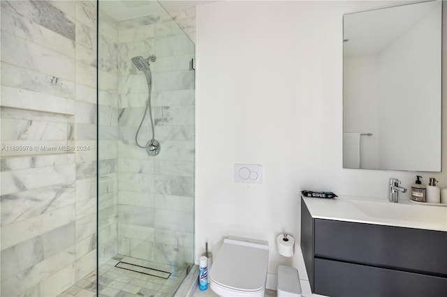 bathroom with vanity, toilet, and a tile shower