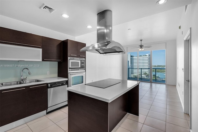 kitchen featuring visible vents, island exhaust hood, a sink, stainless steel appliances, and light countertops