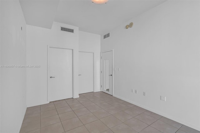 unfurnished bedroom with light tile patterned floors and visible vents