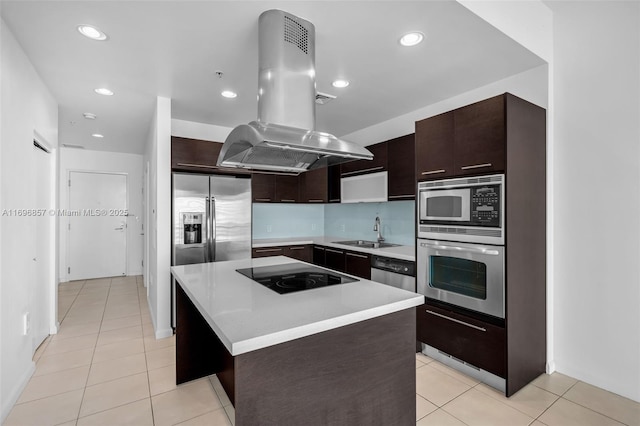 kitchen featuring island exhaust hood, a sink, stainless steel appliances, dark brown cabinetry, and light countertops