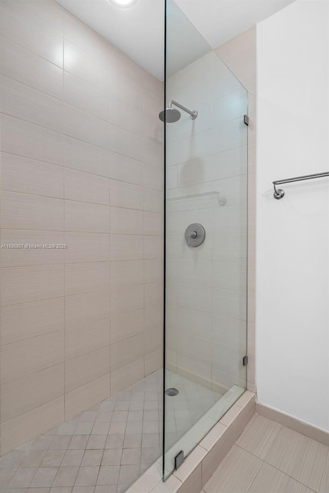 full bathroom with baseboards and tiled shower