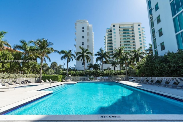 community pool featuring a patio area and fence