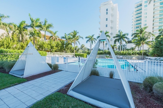 view of community with a pool and fence