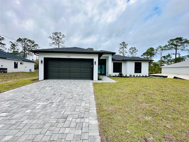 view of front of property with a front yard and a garage