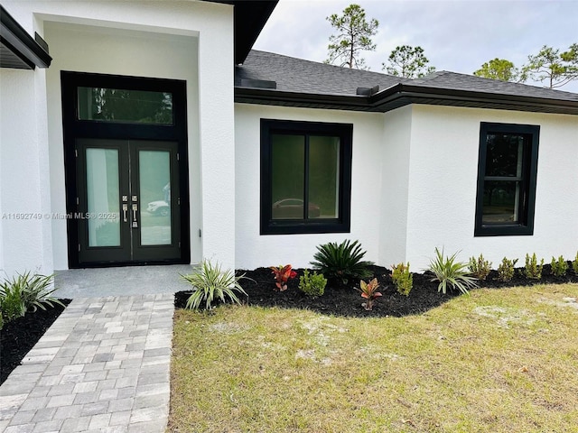 doorway to property with french doors and a lawn