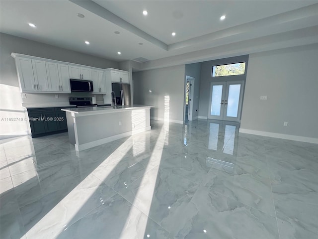 kitchen with a center island, white cabinetry, appliances with stainless steel finishes, and french doors