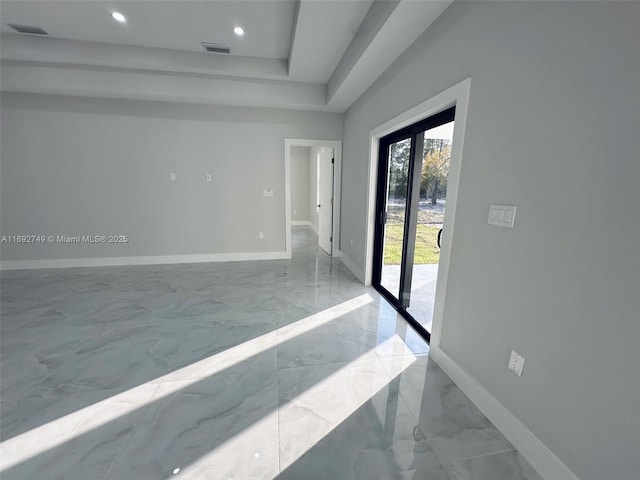 unfurnished room with a tray ceiling