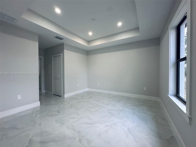 unfurnished room featuring a raised ceiling