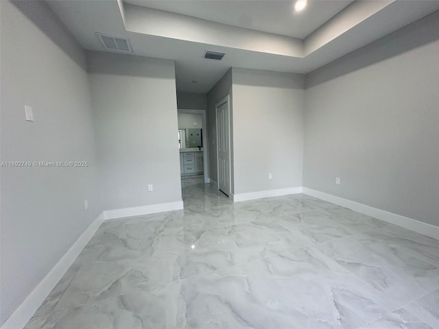 unfurnished room with a raised ceiling