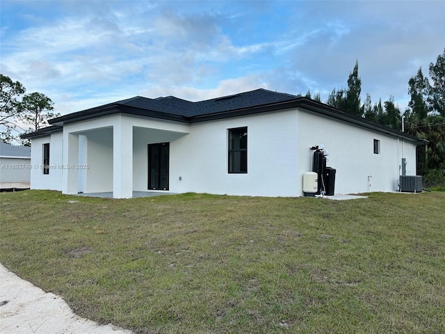 rear view of property with a yard and cooling unit