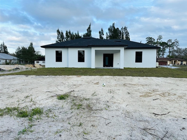 rear view of house featuring a lawn