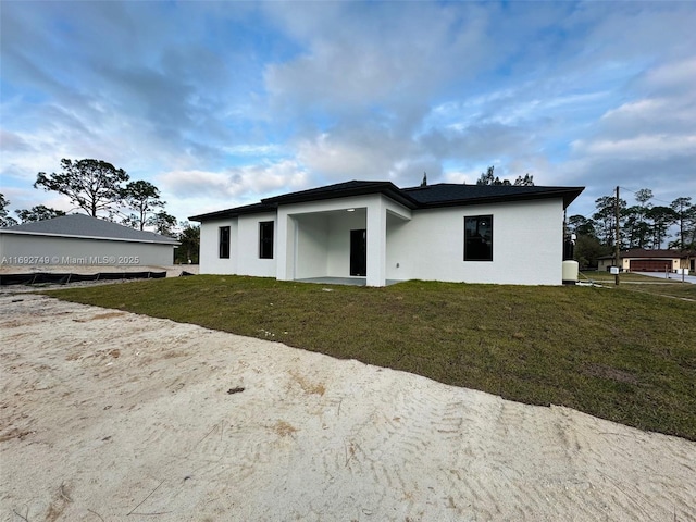 rear view of house featuring a lawn