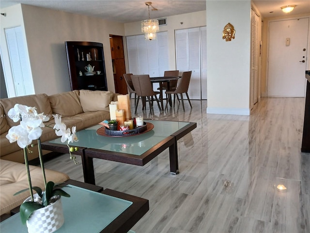 living room featuring a chandelier and light hardwood / wood-style flooring