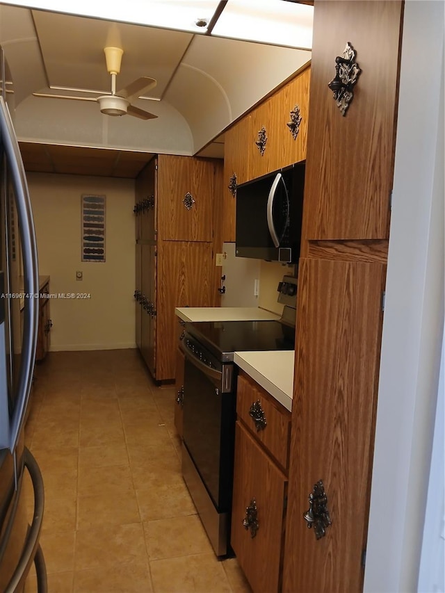 kitchen featuring appliances with stainless steel finishes, light tile patterned floors, and ceiling fan