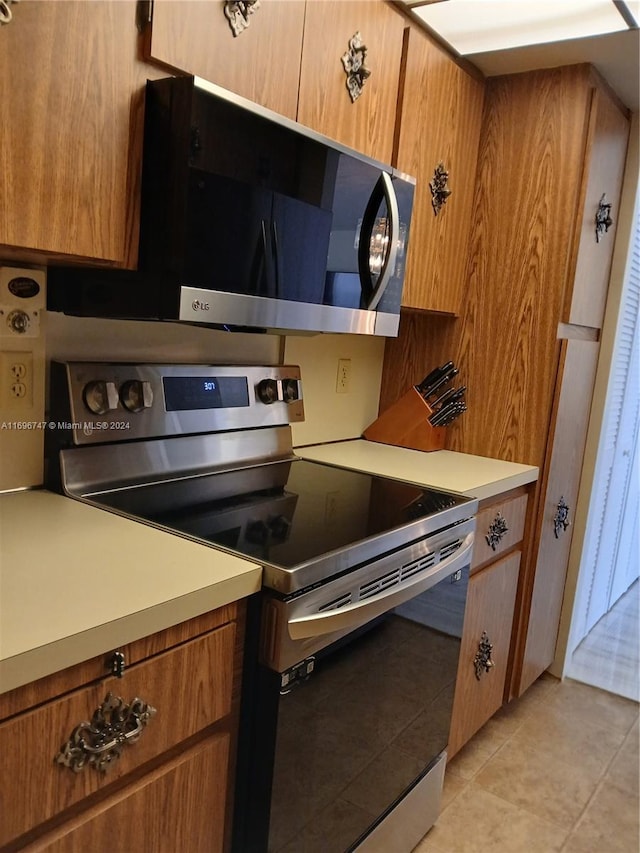 kitchen featuring light tile patterned floors and appliances with stainless steel finishes