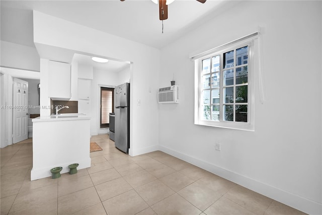 tiled spare room with an AC wall unit, ceiling fan, and sink