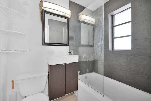 full bathroom with tiled shower / bath combo, toilet, and vanity