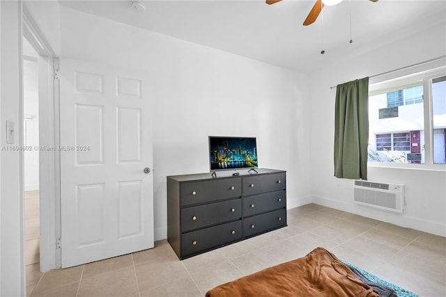 tiled bedroom featuring a wall unit AC and ceiling fan