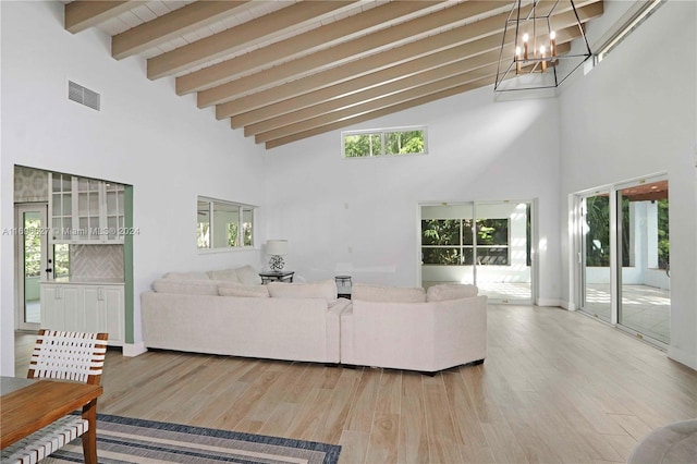 living room with beam ceiling, high vaulted ceiling, a notable chandelier, and hardwood / wood-style floors