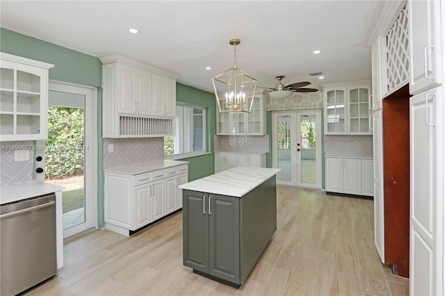 kitchen with a center island, french doors, light hardwood / wood-style flooring, backsplash, and white cabinets