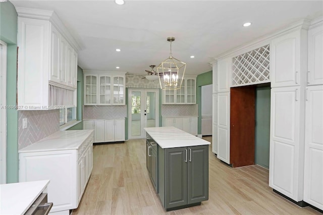 kitchen with white cabinets, a center island, gray cabinets, and hanging light fixtures