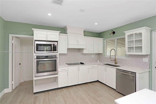 kitchen featuring white cabinets, light hardwood / wood-style floors, sink, and appliances with stainless steel finishes