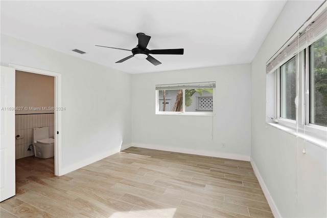 unfurnished bedroom featuring connected bathroom, light hardwood / wood-style flooring, and ceiling fan