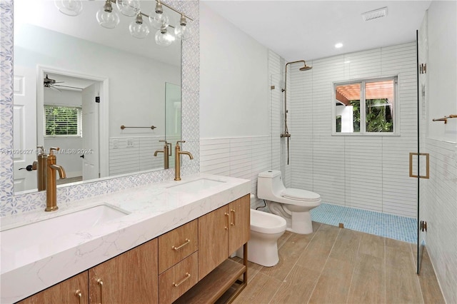 bathroom with toilet, tile walls, and a wealth of natural light