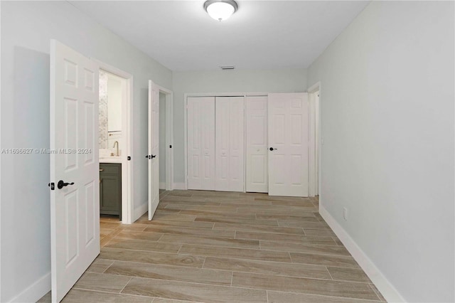 corridor featuring sink and light hardwood / wood-style flooring