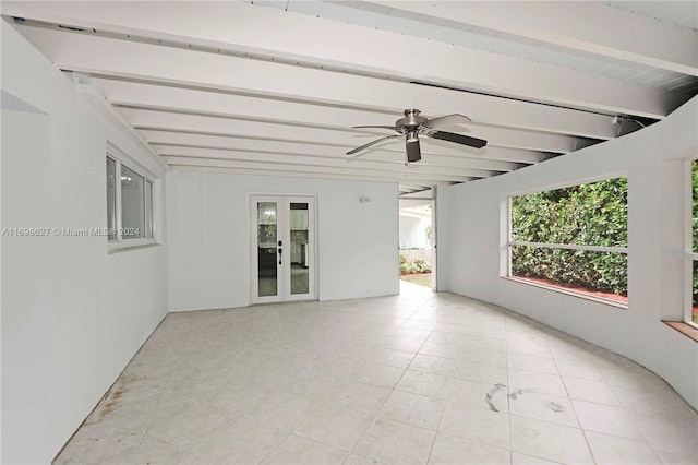 tiled spare room with beamed ceiling, ceiling fan, and french doors