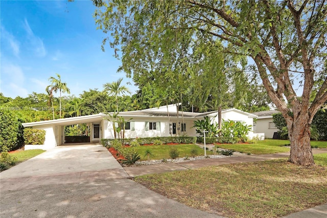 single story home featuring a front yard and a carport