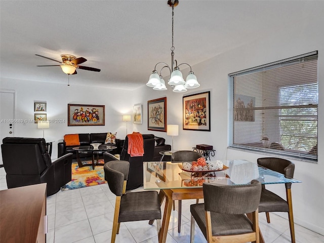 tiled dining area featuring ceiling fan with notable chandelier